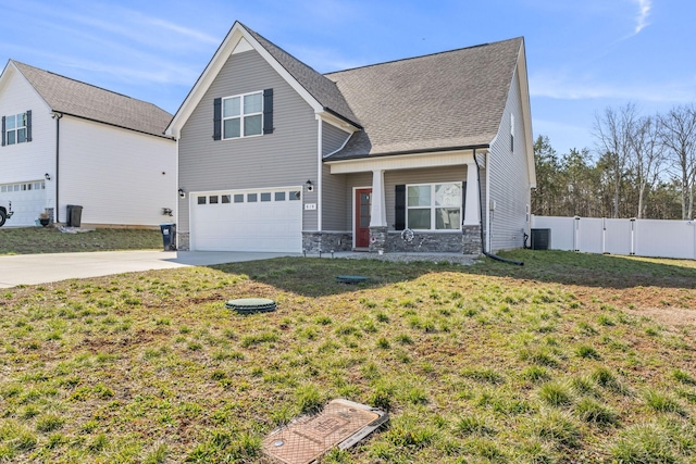 view of front of property with driveway, stone siding, central AC, fence, and an attached garage