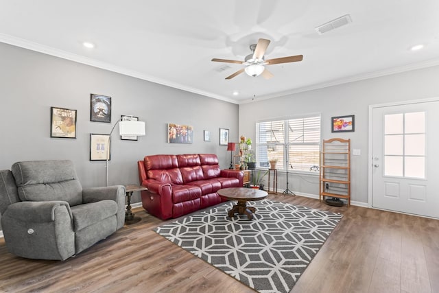 living room with visible vents, wood finished floors, and crown molding