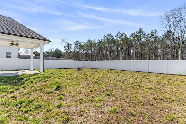 view of yard with ceiling fan and a fenced backyard