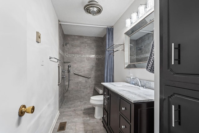 full bath featuring vanity, visible vents, tiled shower, a textured ceiling, and toilet