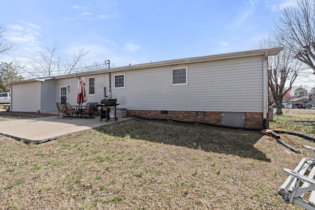 rear view of house featuring crawl space, a yard, and a patio