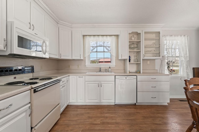 kitchen featuring a sink, white appliances, a textured ceiling, and plenty of natural light