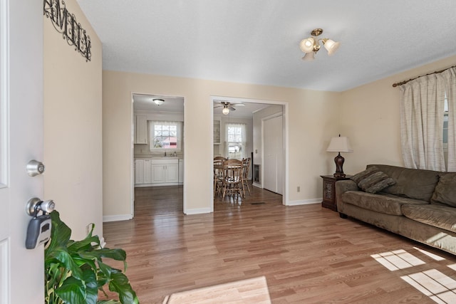 living area featuring light wood finished floors and baseboards