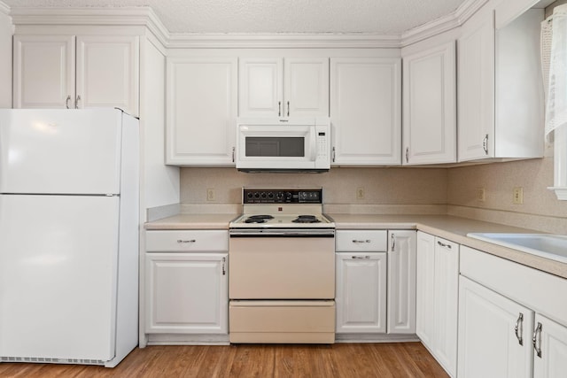 kitchen featuring white appliances, white cabinets, and light countertops