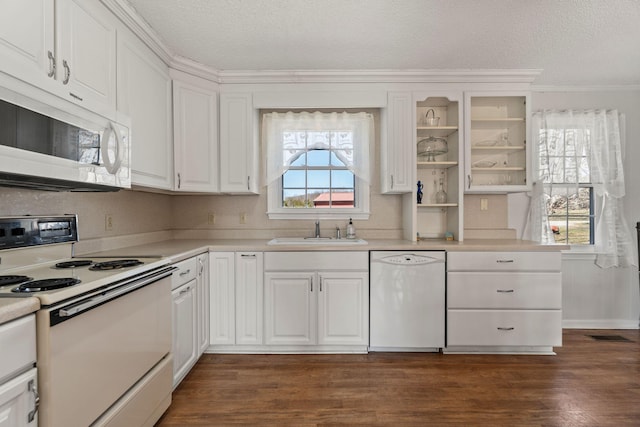 kitchen with a sink, white appliances, a textured ceiling, and dark wood-style flooring