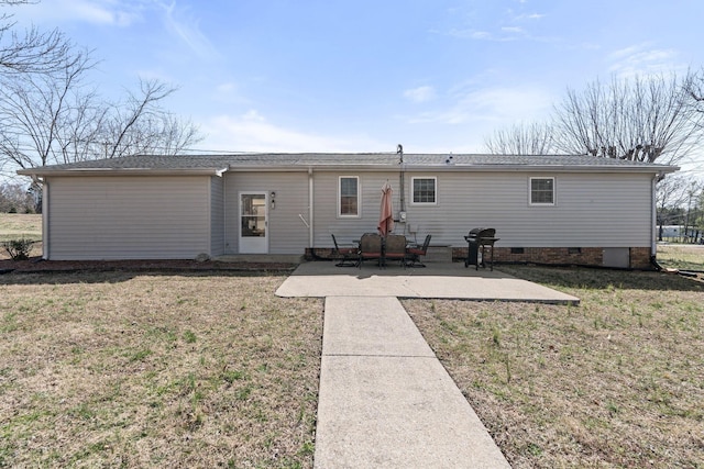 rear view of property featuring a patio, a yard, and crawl space