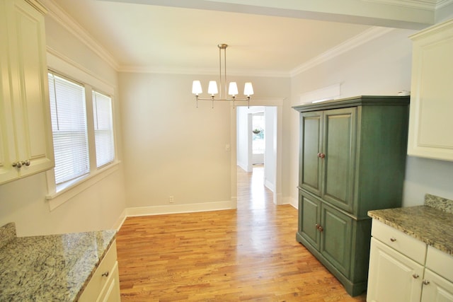 kitchen with crown molding, baseboards, a chandelier, pendant lighting, and light wood-type flooring