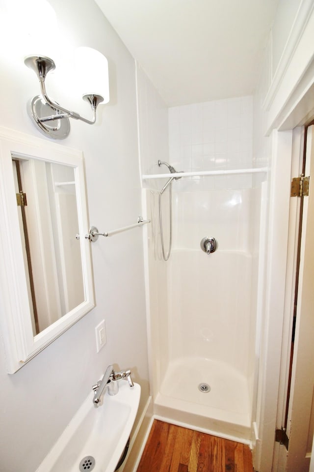 full bathroom featuring a shower and wood finished floors