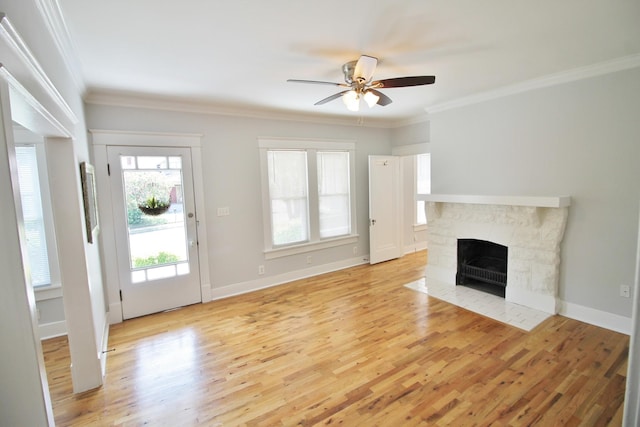 unfurnished living room with light wood-style flooring, baseboards, ornamental molding, and a fireplace