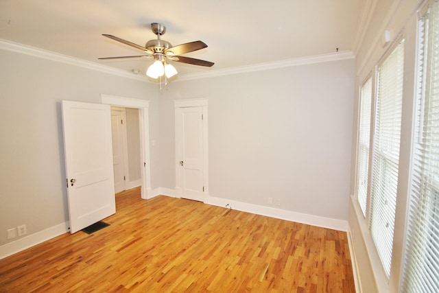 unfurnished bedroom with crown molding, light wood-style floors, baseboards, and visible vents