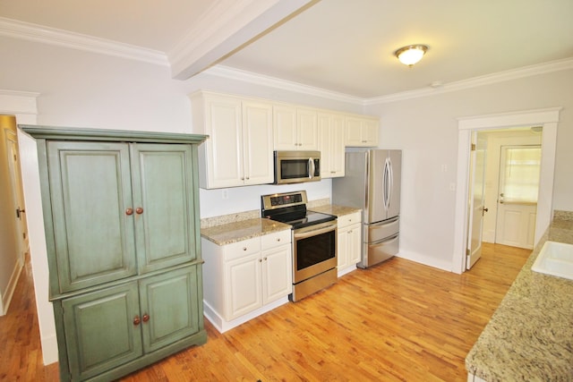 kitchen featuring light wood finished floors, appliances with stainless steel finishes, and ornamental molding