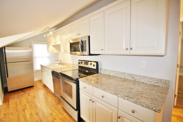 kitchen featuring a sink, white cabinetry, light wood finished floors, and stainless steel appliances