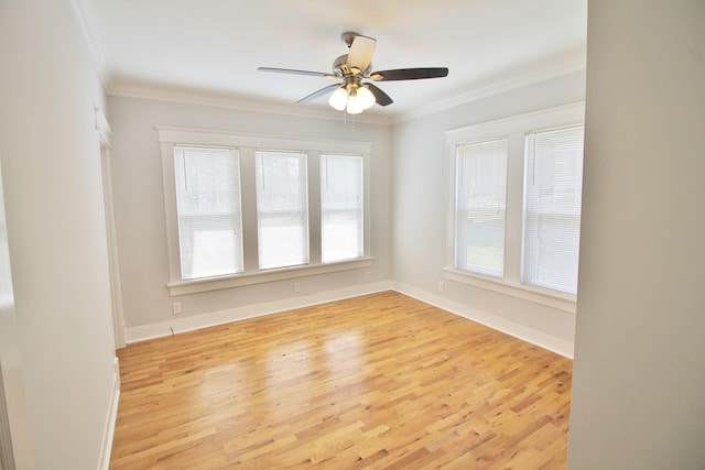 empty room with crown molding, wood finished floors, and baseboards