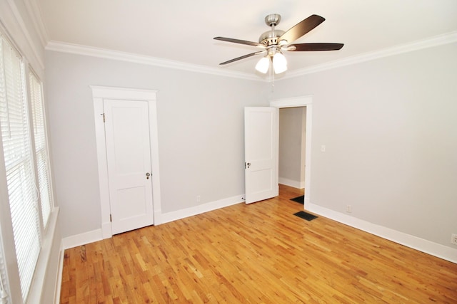 unfurnished bedroom featuring light wood-style flooring, baseboards, visible vents, and ornamental molding