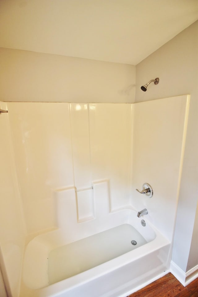 bathroom featuring bathtub / shower combination and wood finished floors