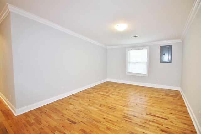 unfurnished room with crown molding, electric panel, light wood-style floors, and visible vents