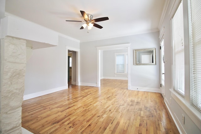 empty room with light wood-style flooring, baseboards, ornamental molding, and a ceiling fan