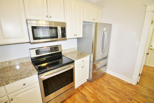 kitchen featuring light wood-type flooring, white cabinetry, stainless steel appliances, baseboards, and light stone countertops