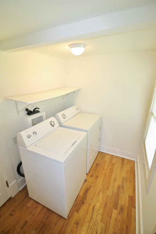 washroom with laundry area, baseboards, light wood finished floors, and washer and clothes dryer