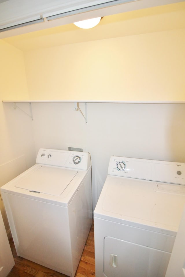 laundry room featuring laundry area, washer and dryer, and wood finished floors