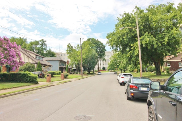 view of road featuring curbs, street lights, and sidewalks