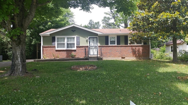 view of front of home featuring brick siding, crawl space, an outdoor fire pit, and a front yard