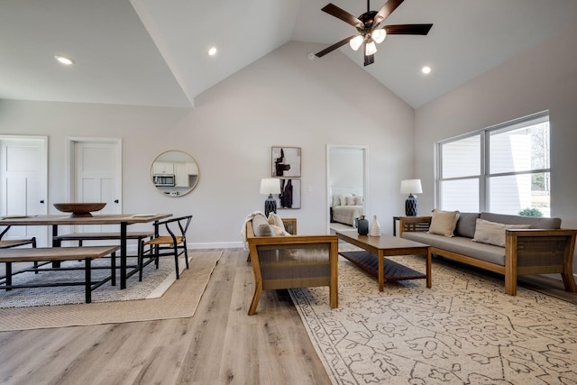 living room featuring high vaulted ceiling, recessed lighting, light wood-style floors, baseboards, and ceiling fan