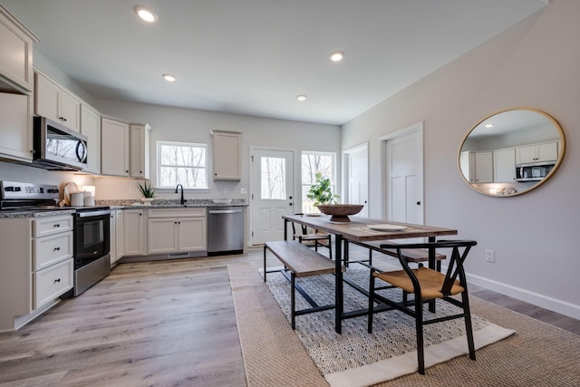 kitchen with recessed lighting, stainless steel appliances, baseboards, and light wood-style floors