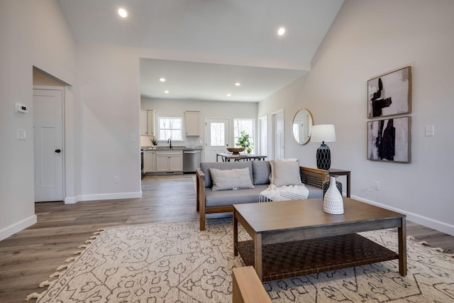 living area with vaulted ceiling, light wood-style flooring, recessed lighting, and baseboards