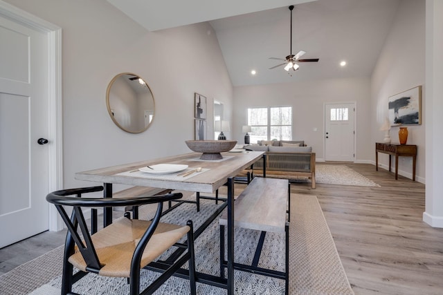 dining area featuring light wood finished floors, baseboards, recessed lighting, high vaulted ceiling, and a ceiling fan