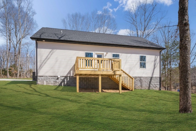 rear view of property featuring stairway, a lawn, a deck, and roof with shingles