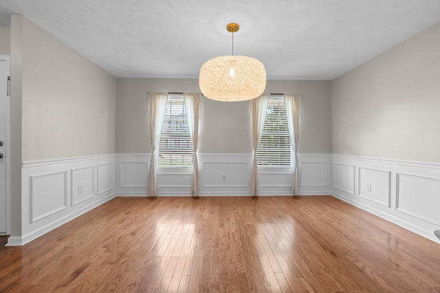 empty room with a wealth of natural light and wood-type flooring