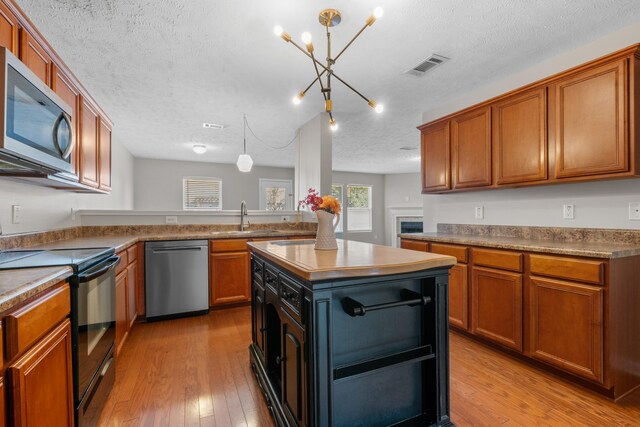 kitchen with light wood-type flooring, visible vents, appliances with stainless steel finishes, and a sink