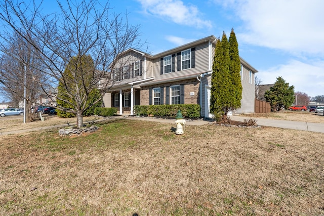 traditional home with brick siding and a front lawn