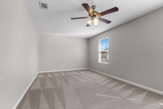 spare room with visible vents, a textured ceiling, carpet, baseboards, and ceiling fan