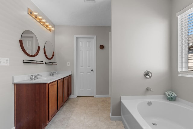 full bath with a garden tub, double vanity, tile patterned floors, and a sink