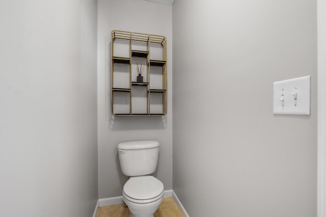 bathroom with tile patterned floors, baseboards, and toilet