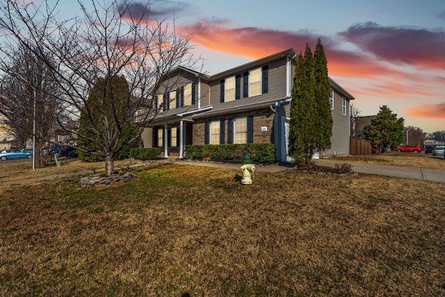 traditional home with a yard and brick siding