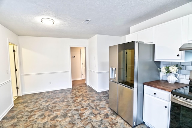 kitchen with visible vents, wood counters, white cabinetry, appliances with stainless steel finishes, and extractor fan