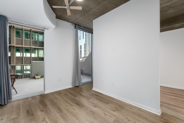 spare room featuring wood finished floors, baseboards, and ceiling fan