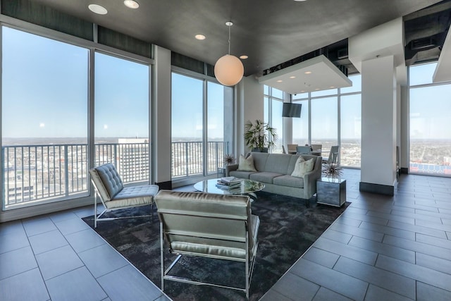 living area with expansive windows, plenty of natural light, and dark tile patterned floors