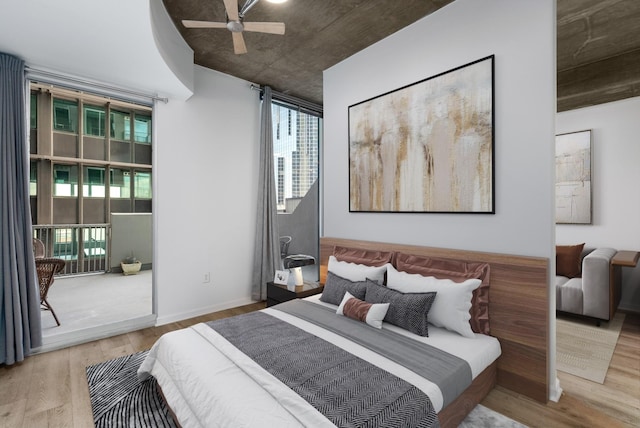 bedroom with a ceiling fan, access to outside, and wood finished floors