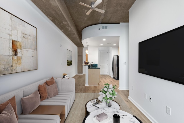 living room with baseboards, visible vents, light wood finished floors, and ceiling fan