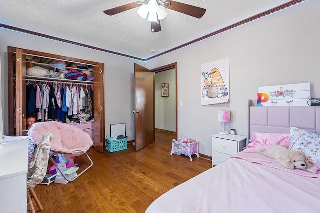 bedroom featuring a closet, a textured ceiling, ceiling fan, and wood finished floors