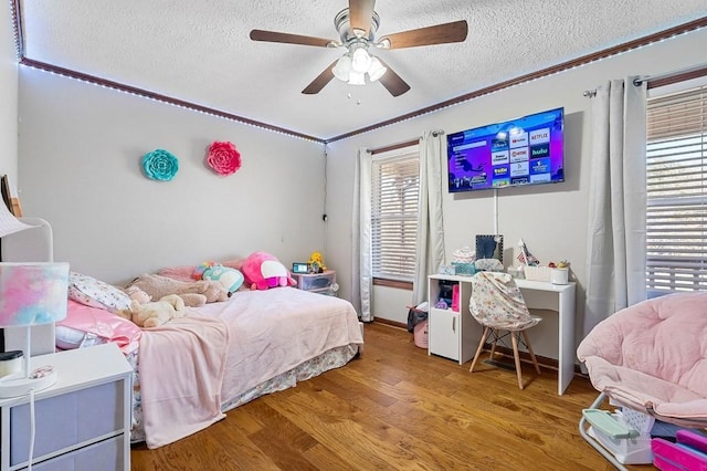 bedroom featuring a textured ceiling, a ceiling fan, and wood finished floors