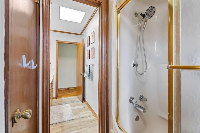 full bathroom featuring ornamental molding, shower / tub combination, baseboards, and wood finished floors