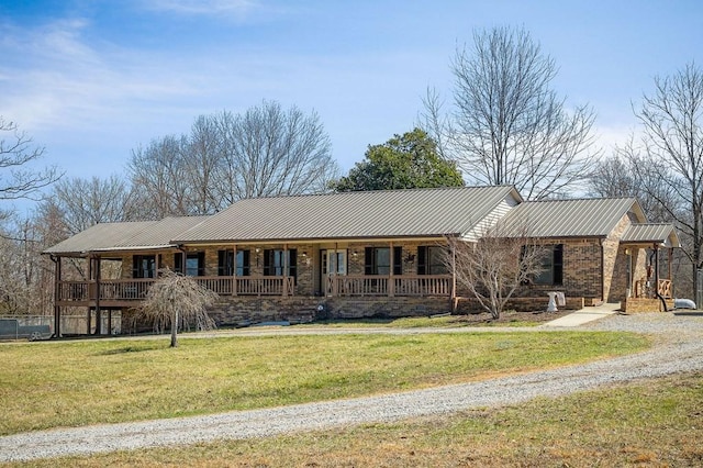 ranch-style house with a porch, brick siding, a front yard, and metal roof