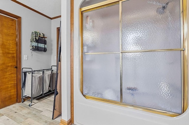 bathroom featuring ornamental molding, wood finished floors, and a textured ceiling