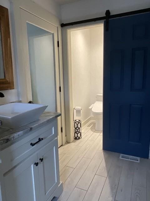 200 Marlin Rd, White House, TN 37188 - half bathroom with vanity, toilet, wood finished floors, and visible vents