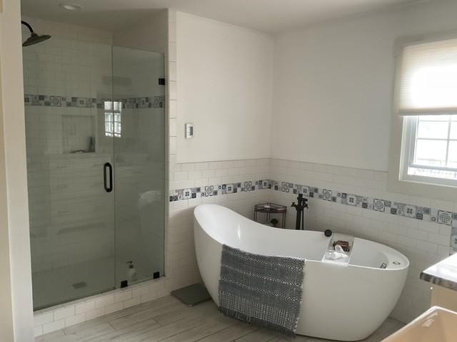 200 Marlin Rd, White House, TN 37188 - full bath with a wainscoted wall, wood finished floors, tile walls, a shower stall, and a freestanding bath